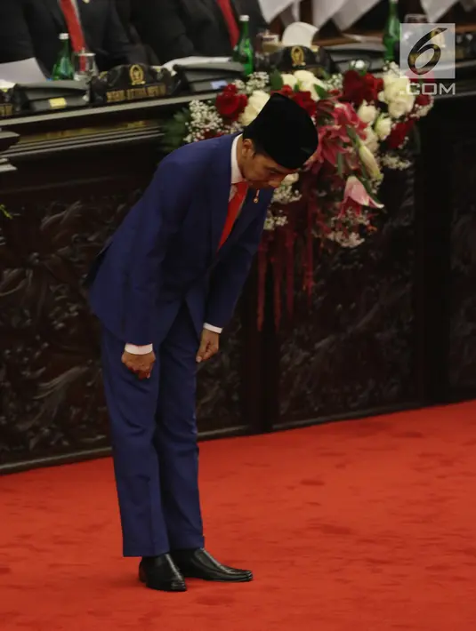 Presiden Joko Widodo membungkukan badan ke arah anggota dewan sebelum menyampaikan Pidato Kenegaraan pada Sidang Tahunan MPR 2019 di Kompleks Parlemen, Senayan, Jakarta, Jumat (16/8/2019). Jokowi akan menyampaikan pidato dalam tiga sesi dengan tema yang berbeda. (Liputan6.com/Johan Tallo)