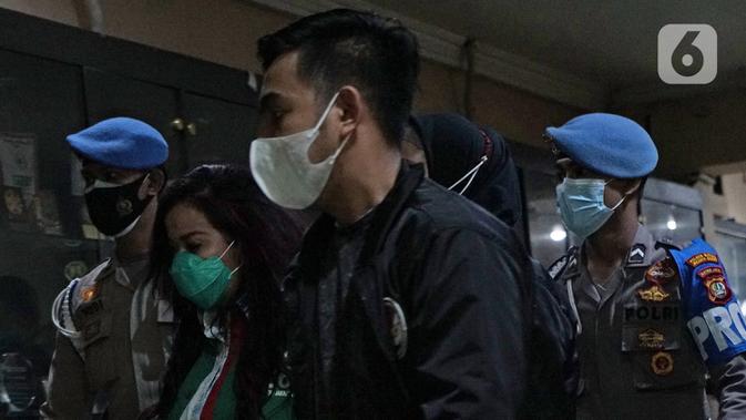 Polisi membawa Jennifer Jill (kedua kiri) untuk rilis kasus Narkoba di Polda Metro Jaya, Jakarta, Jumat (19/02/2021). Jennifer Jill ditetapkan sebagai tersangka kepemilikan barang bukti berupa 2 paket plastik kecil sabu-sabu dengan berat 0,39 gram beserta alat pengisap. (Liputan6.com/Herman Zakharia