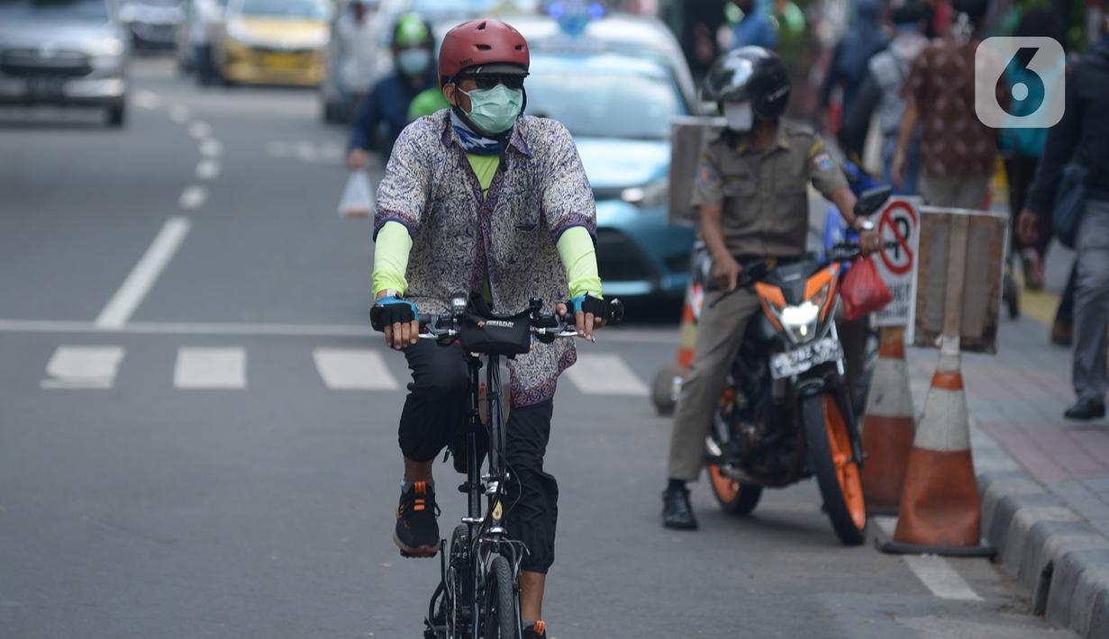 Seorang pria yang mengenakan baju batik bersepeda di kawasan Thamrin Sudirman, Jakarta, Jumat (2/10/2020). Pada Hari Batik Nasional yang berlangsung di tengah pandemi COVID-19, sebagian masyarakat terlihat mengenakan baju dan masker dengan motif batik. (merdeka.com/Imam Buhori)