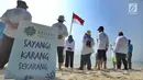 Aktivis Yayasan Kehati Jakarta  dan penjaga pulau melakukan upacara bendera menghadap laut dalam rangka HUT ke-74 RI di Pulau Sangiang, Banten, Minggu (18/8/2019). Kegiatan ini dilakukan serentak secara nasional di 73 titik untuk mencintai laut dan sumber daya alamnya. (merdeka.com/Arie Basuki)