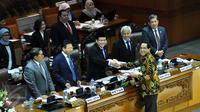Wakil Ketua Badan Legislasi (Baleg) DPR Firman Soebagyo (berbaju batik) menyerahkan laporan kepada pimpinan DPR saat Rapat Paripurna ke-13 Masa Persidangan II tahun 2015-2016 di Komplek Parlemen, Jakarta, Selasa (15/12/2015). (Liputan6.com/Johan Tallo)