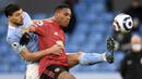 Striker Manchester United, Anthony Martial (kanan) berebut bola dengan bek Manchester City, Ruben Dias dalam laga lanjutan Liga Inggris 2020/21 di Etihad Stadium, Minggu (7/3/2021). MU menang 2-0 atas Mancity. (AFP/Peter Powell/Pool)
