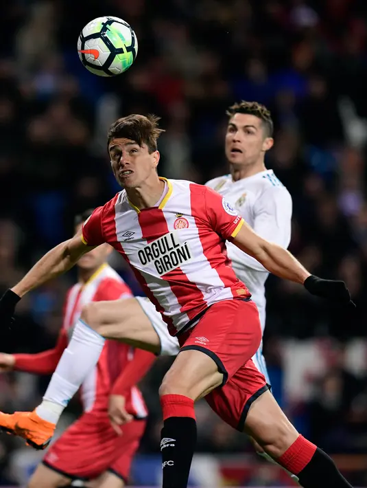 Bek Girona Bernardo Espinosa berusaha menghadang bola saat melawan Real Madrid Girona dalam pertandingan La Liga Spanyol di stadion Santiago Bernabeu di Madrid (18/3). (AFP Photo / Javier Sorioano)
