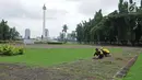 Petugas membersihkan taman di kawasan Monas, Jakarta, Rabu (23/1). DPRD meminta Pemprov DKI Jakarta untuk menjaga keamanan pengunjung saat dilakukan penataan. (Liputan6.com/Herman Zakharia)