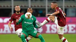 Pemain Fiorentina Kevin-Prince Boateng (tengah) berebut bola dengan pemain AC Milan Ismael Bennacer saat bertanding pada Serie A di Stadion San Siro, Milan, Italia, Minggu ( 29/9/2019). AC Milan kalah 1-3 saat menjamu Fiorentina. (AP Photo/Antonio Calanni)
