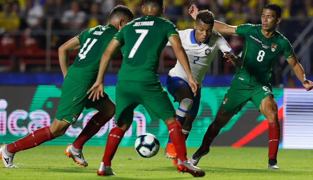 Gelandang Brasil, David Neres berusaha melewati tiga pemain Bolivia selama pertandingan grup A Piala Copa America 2019 di stadion Morumbi di Sao Paulo, Brasil (14/6/2019). Brasil menang telak 3-0 atas Bolivia. (AP Photo/Victor Caivano)