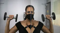 Seorang wanita India terlihat di cermin saat berolahraga di tempat gym yang dibuka kembali setelah lockdown di Gauhati, India, Rabu, (5/8/2020). India memiliki jumlah virus coronavirus tertinggi ketiga di dunia setelah Amerika Serikat dan Brasil. (AP Photo/Anupam Nath)