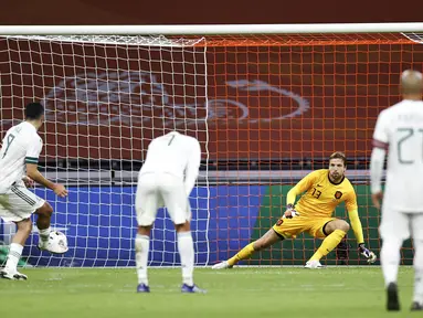 Penyerang Meksiko, Raul Jimenez (Kiri) melakukan tendangan penalti melawan penjaga gawang Belanda Tim Krul dalam pertandingan persahabatan antara Belanda dan Meksiko di Johan Cruyff Arena di Amsterdam (7/10/2020). Meksiko menang 1-0 atas Belanda. (AFP/ANP/Maurice Van Steen)