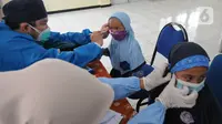 Paramedis dari Puskesmas Cinere memeriksa kesehatan murid kelas 1  saat kegiatan Bulan Imunisasi Anak Sekolah (BIAS) di SDI Al-Hidayah, Depok, Jawa Barat, Kamis (18/11/2021). Pemberian imunisasi measles rubella (MR) dan difteri tetanus (DT) berlangsung hingga Desember. (merdeka.com/Arie Basuki)