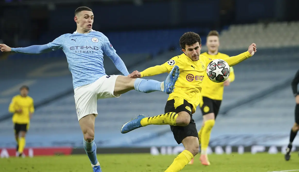Gelandang Manchester City, Phil Foden berebut bola dengan bek Borussia Dortmund, Mateu Morey pada leg pertama perempat final Liga Champions di Etihad Stadium, Rabu (7/4/2021) dini hari WIB. Man City menjungkalkan Dortmund dengan skor 2-1. (AP Photo/Dave Thompson)