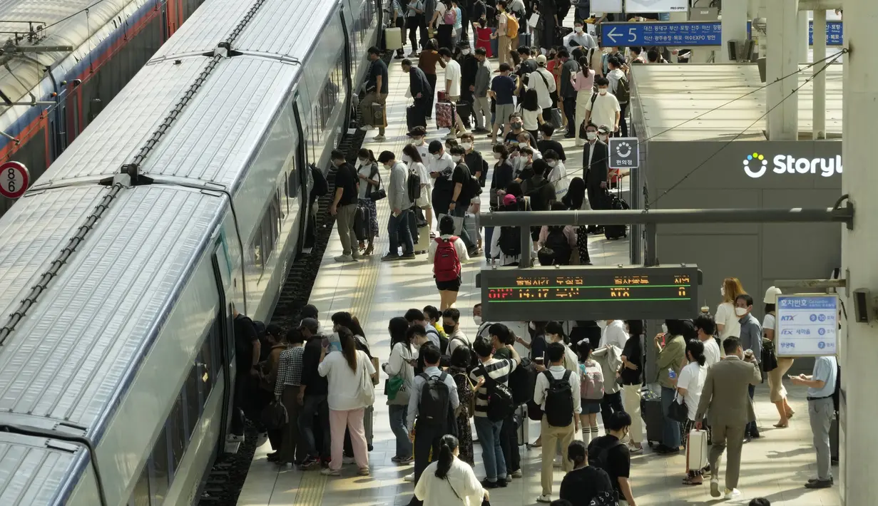Orang-orang yang memakai masker berbaris untuk naik kereta menjelang liburan "Chuseok" di Stasiun Kereta Seoul di Seoul, Korea Selatan, Kamis (8/9/2022). Chuseok" atau Hari Thanksgiving versi Korea, jatuh pada 10 September 2022. ( AP Photo/Ahn Young-joon)