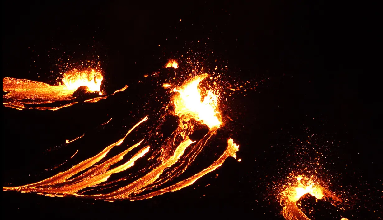 Lava mengalir dari gunung berapi Fagradalsfjall yang meletus, sekitar 40 km dari ibu kota Islandia, Reykjavik, pada Jumat (19/3/2021). Kantor Meteorologi Islandia mengatakan letusan memicu awan merah hingga menerangi langit malam di daerah sekitar. (Icelandic Coast Guard/AFP)