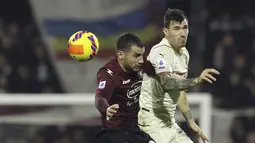 Penyerang Salernitana Federico Bonazzoli berebut bola dengan bek AC Milan Alessio Romagnoli pada giornata ke-26 Liga Italia di Stadion Arechi, Salerno, Minggu (20/2/2022) dini hari WIB. Sempat unggul terlebih dahulu, AC Milan harus puas bermain imbang 1-1. (Alessandro Garofalo/LaPresse via AP)