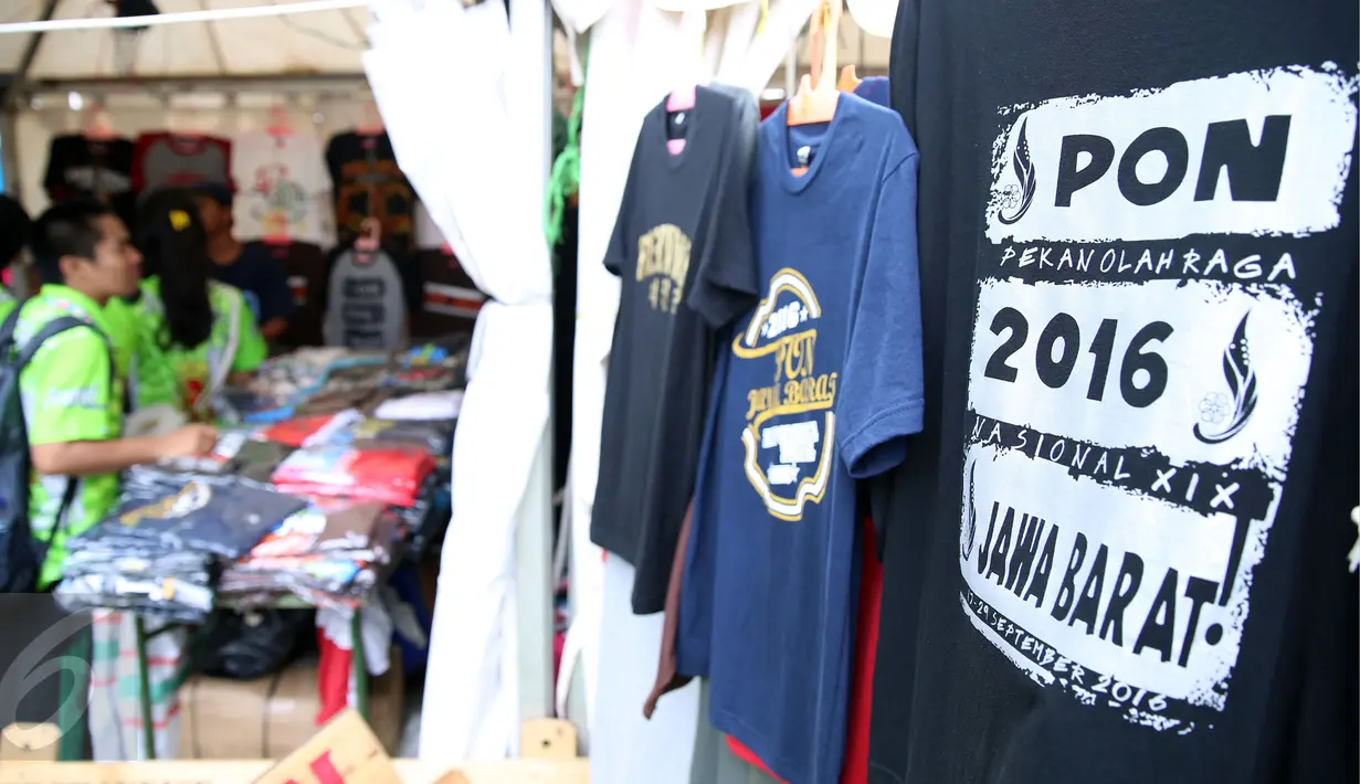 Salah satu anggota kontingen memilih kaos berdesain PON XIX Jabar di GOR Universitas Pendidikan Indonesia, Senin (19/9). Beberapa pedagang memanfaatkan moment PON XIX Jabar untuk menjual beragam pernak pernik. (Liputan6.com/Helmi Fithriansyah) 