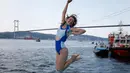 Seorang Atlet renang wanita bergembira setelah mengikuti lomba renang dari Asia hingga Eropa di Selat Bosphorus ke-30, Istanbul, Turki, (22/7). (AP Photo/Lefteris Pitarakis)