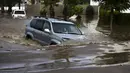 Seorang pengendara mobil mencoba menerobos banjir yang merendam selatan kota Ashkelon, Senin (9/11).  Hujan di Ashkelon yang kurang dari satu jam telah membuat kota ini kebanjiran. (REUTERS/Amir Cohen)