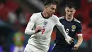 Gelandang Inggris, Jack Grealish membawa bola dari kawalan pemain Skotlandia, Kieran Tierney pada pertandingan grup D Euro 2020 di stadion Wembley, di London, Jumat (18/6/2021). Tambahan satu poin dari laga lawan Skotlandia membuat Inggris kini mengoleksi empat poin. (Justin Tallis/Pool via AP)