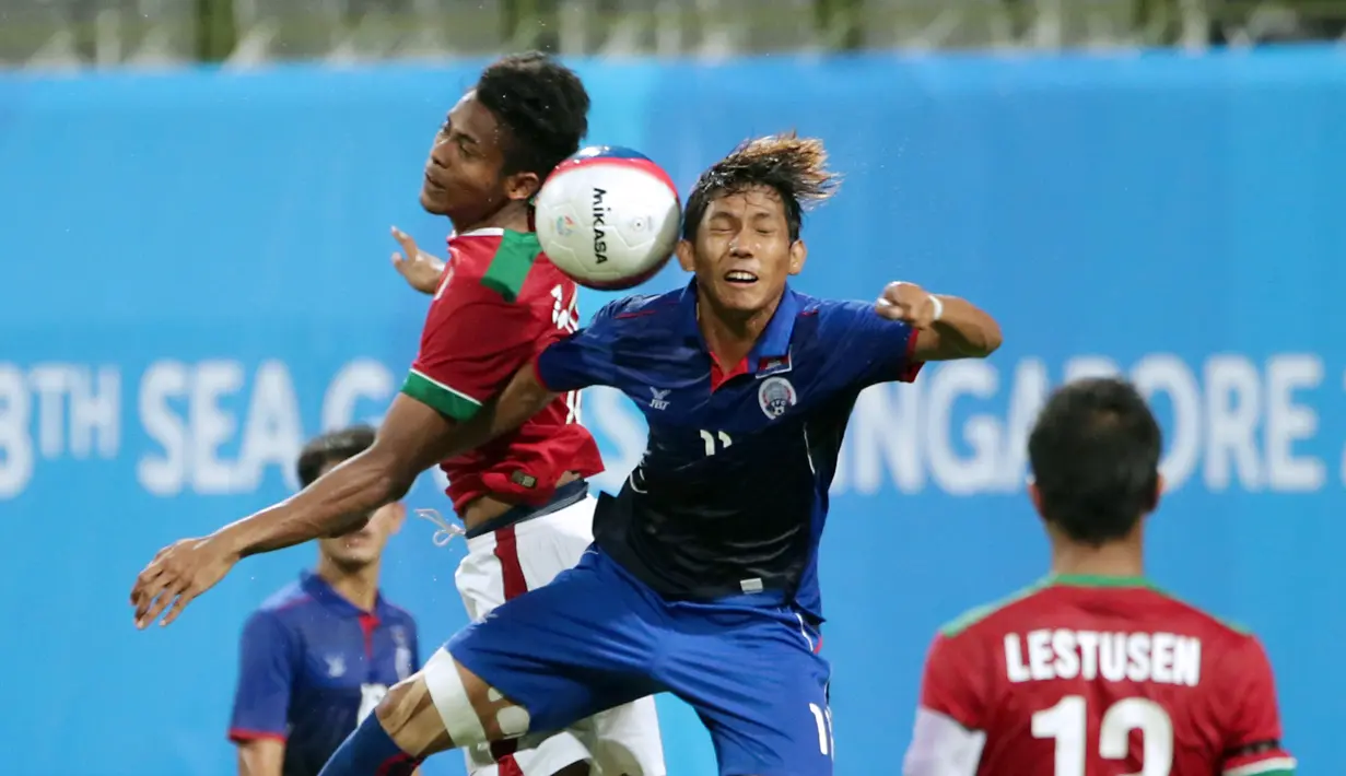 Gelandang timnas Indonesia U-23, Zulfiandi (kiri) berebut bola dengan Vathanaka Chan (Kamboja) di penyisihan Grup A Sea Games 2015 di Stadion Jalan Besar, Singapura, Sabtu (6/6/2015). Indonesia unggul 6-1 atas Kamboja. (Liputan6.com/Helmi Fithriansyah)