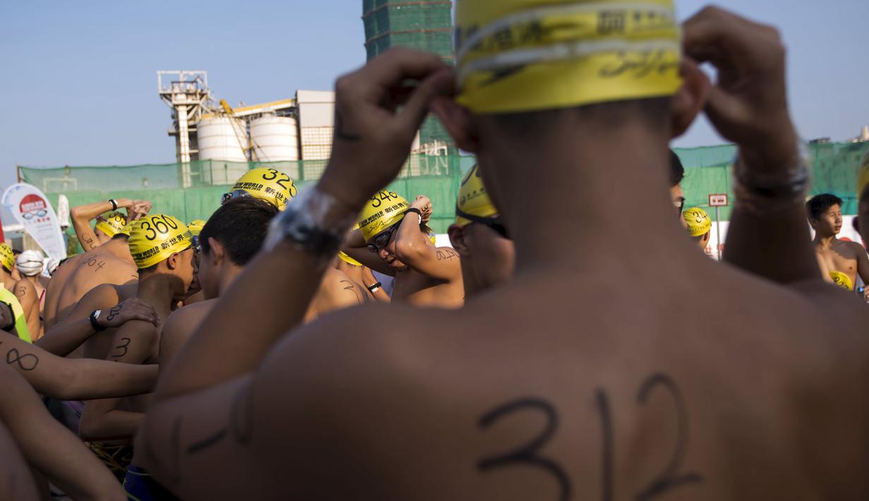 Perenang bersiap mengikuti lomba renang lintas pelabuhan di Hong Kong, Minggu (18/10). 2.500 orang ambil bagian dalam menembus jarak lintasan laut sejauh 1,5 km dari Sam Ka Tsuen Public Pier ke Quarry Bay Park Public Pier. (REUTERS/Tyrone Siu)