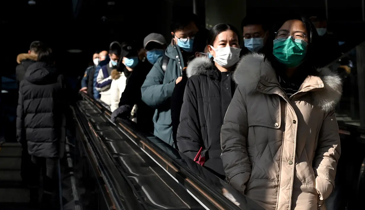 Orang-orang menggunakan eskalator di stasiun kereta bawah tanah di Beijing, Kamis (27/1/2022). Tahun Baru Imlek 2022 yang jatuh pada 1 Februari mendatang akan jadi tahun shio macan. (AFP/Noel Celis)