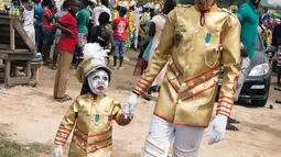 Peserta saat tiba di acara Winneba Fancy Dress di Ghana, Senin (2/1). Festival ini oleh penduduk sekitar dikenal dengan nama Kakamotobi. (AFP PHOTO / Ruth McDowall)