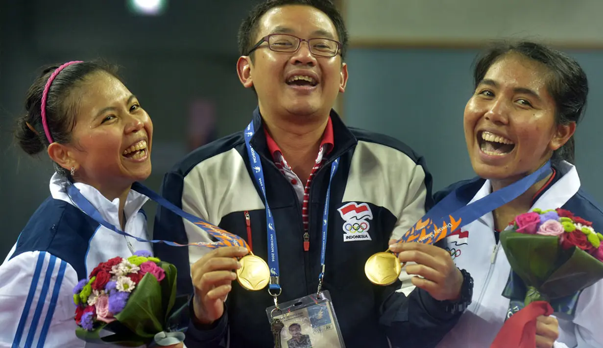 Ganda putri Indonesia Nitya Krishinda (kanan) dan Gresya Polii (kiri) bergembira bersama pelatih mereka Eng Hian (tengah) usai penghargaan medali final perorangan Ganda Putri Asian Games ke-17 di Incheon, Korsel, Sabtu (27/9). (ANTARA FOTO/SAPTONO)