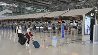 Pelancong berjalan di ruang keberangkatan yang hampir kosong karena jumlah pengunjung menurun drastis di Bandara Suvarnabhumi di Bangkok, Rabu (11/3/2020). Di Thailand sendiri lebih dari 50 orang terinfeksi virus corona COVID-19 yang telah menggemparkan seluruh dunia. (Mladen ANTONOV/AFP)