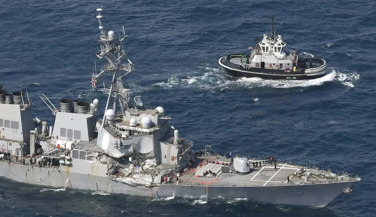 Sebuah kapal tunda menghampiri kapal perusak USS Fitzgerald yang rusak usai bertabrakan dengan kapal dagang di prefektur Shizuoka, Jepang (17/6). Ketujuh pelaut yang sebelumnya dilaporkan hilang ditemukan tewas. (Iori Sagisawa/Kyodo News via AP)