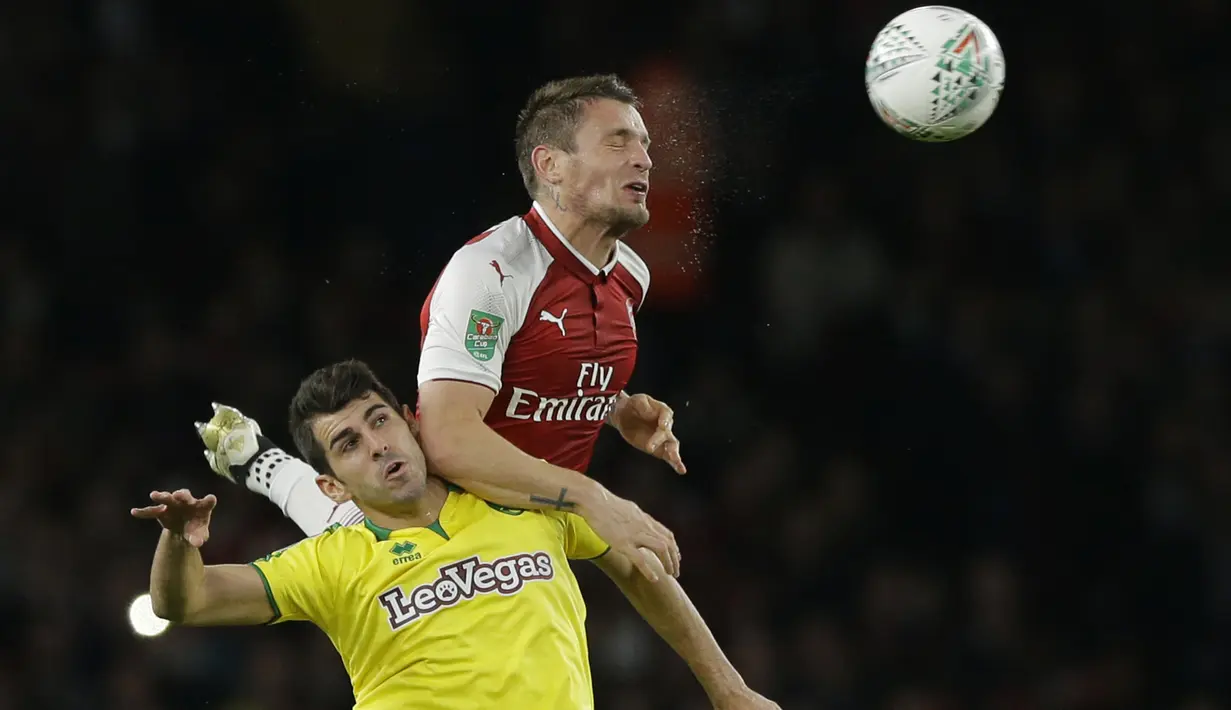 Pemain Arsenal, Mathieu Debuchy menghalau bola dari jangkauan pemain Norwich City, Nelson Oliveira pada laga Piala Liga Inggris di Emirates Stadium, London, (24/10/2017). Arsenal menang 2-1. (AP/Alastair Grant)