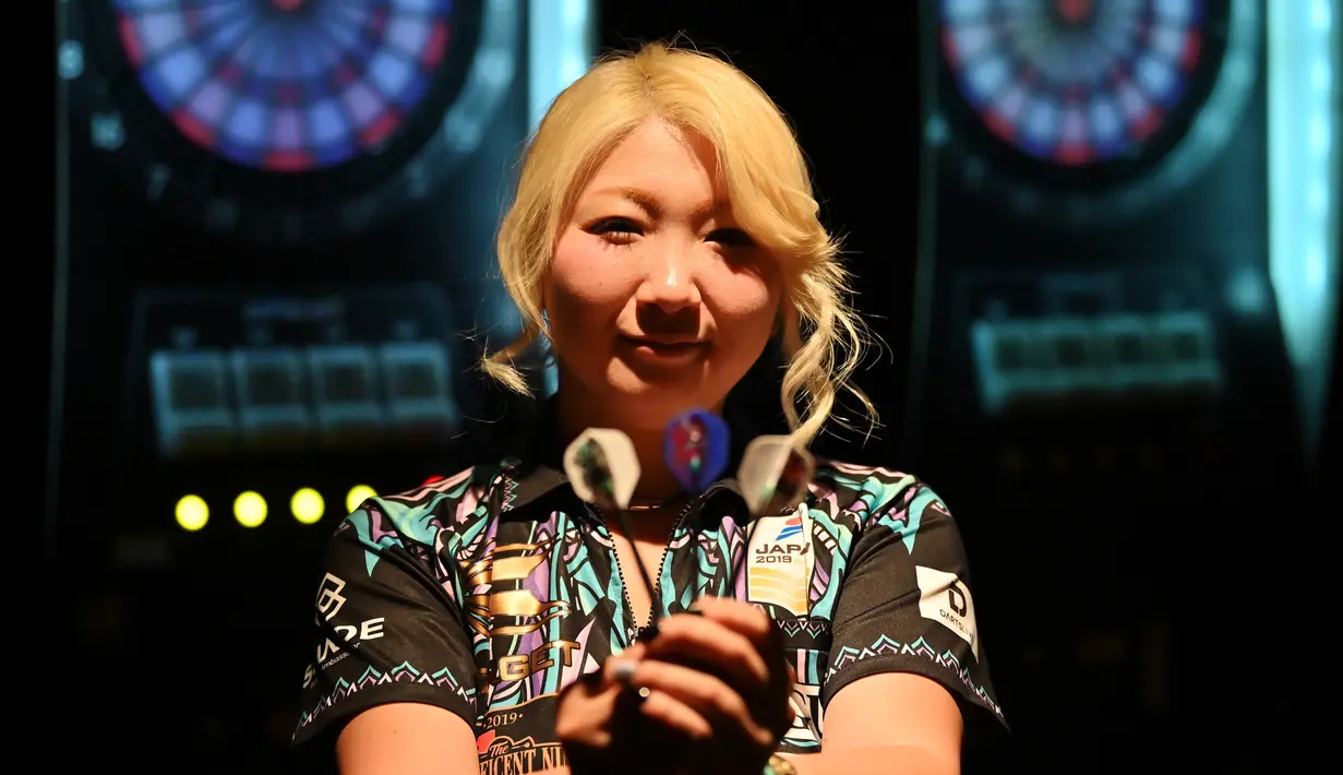 Mikuru Suzuki berpose dengan memegang anak panah untuk bermain darts, Tokyo, Jepang, 8 April 2019. Suzuki naik ke posisi ketiga dalam Federasi Dart Dunia. (CHARLY TRIBALLEAU/AFP)