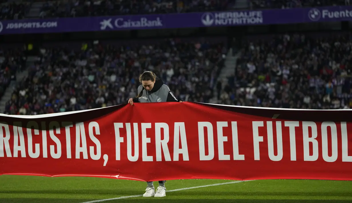 Sebuah spanduk bertuliskan dalam bahasa Spanyol, "Rasis, menjauhlah dari sepak bola" ditampilkan sebelum pertandingan La Liga Spanyol antara Valladolid vs Barcelona di stadion Jose Zorrilla Selasa, 23 Mei 2023. (AP Photo/Manu Fernandez)