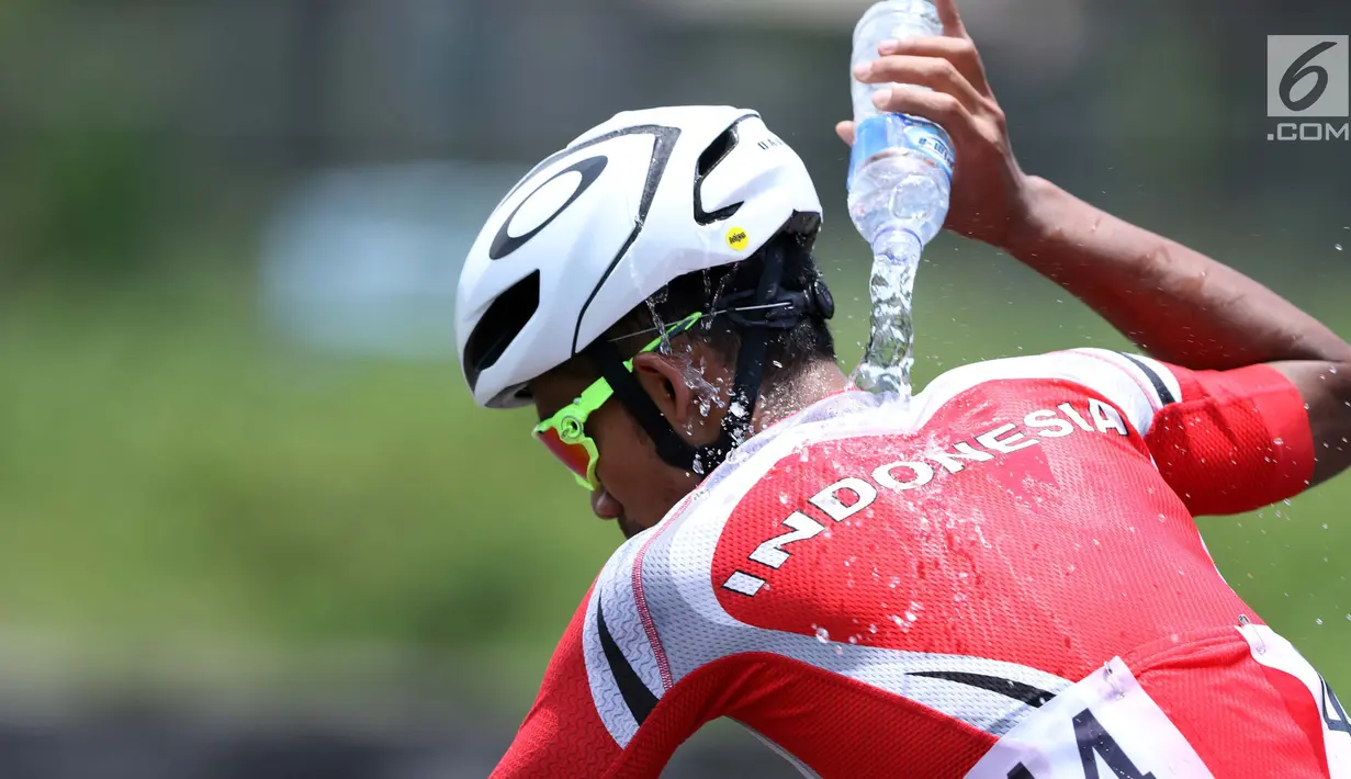 Atlet ParaCycling, M Fadli Immamuddin mengguyur tubuhnya saat laga di nomor Mens C4 Road Race Asian Para Games 2018 di Sirkuit Sentul Bogor, Selasa (9/10). M Fadli menempati posisi keempat. (Liputan6.com/Helmi Fithriansyah)