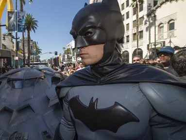 Pria berpakaian Batman berpose depan Batmobil terbaru dalam serial film " Batman v Superman : Dawn of Justice " di Los Angeles, California, (21/10/2015).  Acara Ini merupakan penghargaan terhadap pencipta Batman Bob Kane. (REUTERS/Mario Anzuoni)