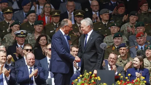 Kanselir Jerman Friedrich Merz (kiri) berjabat tangan dengan Presiden Lithuania Gitanas Nauseda pada peresmian brigade Jerman untuk sayap timur NATO di Vilnius, Lithuania, Kamis (22/5/2025).