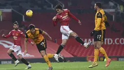 Penyerang Manchester United, Edinson Cavani menyundul bola saat bertanding melawan Wolverhampton Wanderers pada pertandingan lanjutan Liga Inggris di Stadion Old Trafford, Rabu (30/12/2020).Tiga poin dari Wolves menempatkan MU di posisi kedua dengan 30 poin. (Laurence Griffiths, Pool via AP)