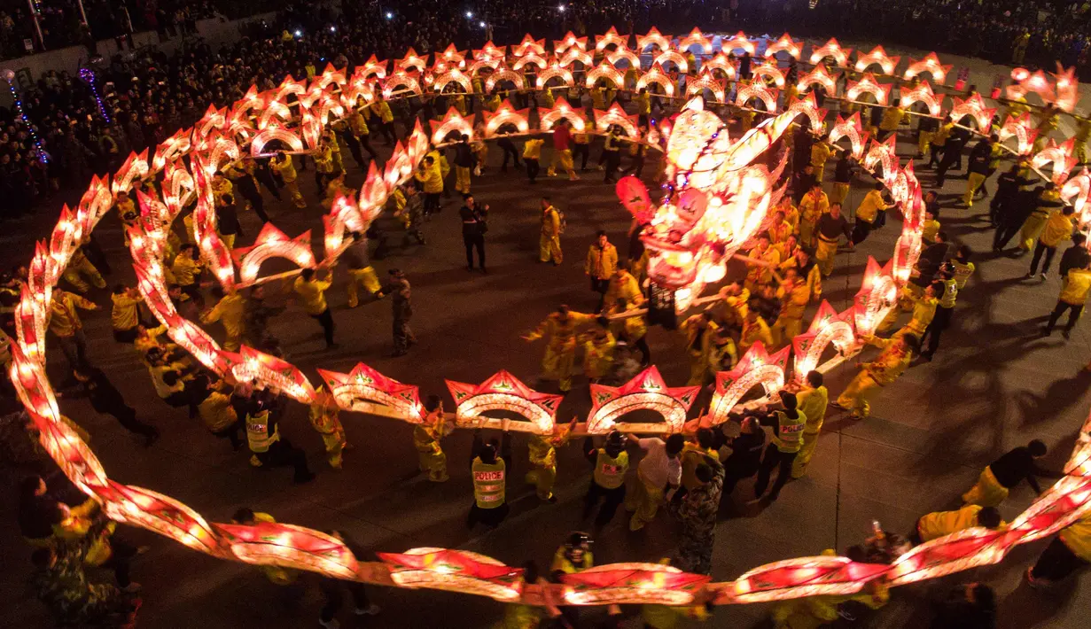 Warga menggunakan lentera melakukan pertunjukkan tarian naga selama festival lentera China di Yunhe di provinsi timur China Zhejiang (1/3). Festival ini jatuh pada 2 Maret, yang menandai berakhirnya perayaan untuk periode Tahun Baru Imlek. (AFP Photo)