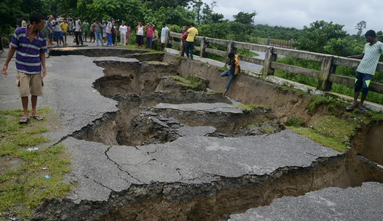 Kondisi sebuah jembatan yang hancur akibat hujan deras yang mengguyur Desa Toribari, pinggiran Siliguri, India, Kamis (21/7). Hujan deras yang terus menerus turun di India dalam 48 jam terakhir menyebabkan banjir dan tanah longsor. (DIPTENDU Dutta/AFP)