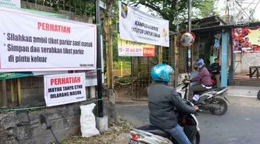 Pengendara motor melintasi akses pintu masuk dan keluar Universitas Indonesia di Depok, Jawa Barat, Selasa (16/7/2019). Penerapan uji coba sistem masuk parkir UI berbayar yang menyebabkan kemacetan panjang membuat gerbang tiket pembayaran kembali dinonaktifkan. (Liputan6.com/Immanuel Antonius)