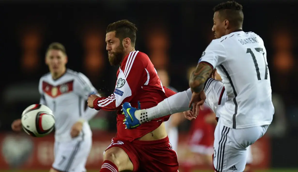 Penyerang Georgia, Levan Mchedlidze (kiri) erusaha merebut bola  dari kejaran Bek Jerman, Jerome Boateng saat kualifikasi Piala Eropa 2016 di Locomotiv Stadium, Minggu (29/3/2015). Jerman menang 2-0 atas Georgia. (AFP PHOTO/Patrik Stollarz)