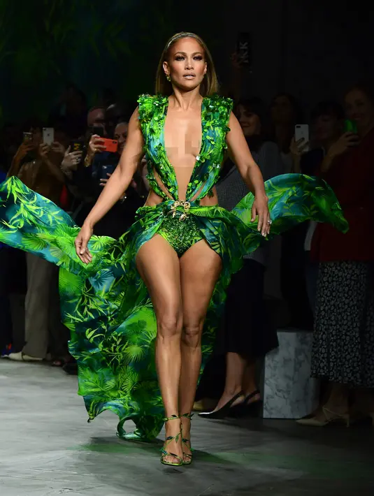 Bintang pop dan aktris Jennifer Lopez menutup peragaan busana Versace untuk Spring/Summer Collection 2020 pada Milan Fashion Week 2019, Jumat (20/9/2019). Jennifer Lopez mengenakan versi baru gaun hijau ikonis yang pernah ia gunakan di Grammy Awards 20 tahun lalu. (Miguel MEDINA/AFP)