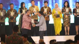 Gubernur Bank Indonesia Perry Warjiyo menyerahkan penghargaan BI Award 2019  kepada Direktur Bisnis Internasional dan Tresuri BNI Bob Tyasika Ananta (kanan) dalam acara Pertemuan Tahunan Bank Indonesia (PTBI) 2019 di Jakarta, Kamis (28/11/2019). (Liputan6.com/Angga Yuniar)