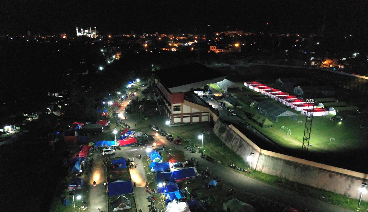 Foto udara menunjukkan tenda-tenda di tempat penampungan darurat di Mamuju (19/1/2021). Basarnas menyebut hingga pukul 16.00 WIB, Senin (18/1/2021) sebanyak 84 orang meninggal akibat gempa yang terjadi di Sulawesi Barat (Sulbar). (AFP/Adek Berry)