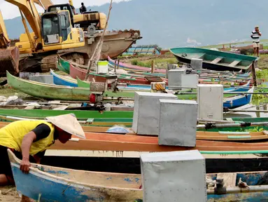 Kotak suara aluminium digunakan untuk menutupi mesin perahu nelayan di Danau Limboto, Gorontalo, Sabtu (26/1). Nalayan menggunakan kotak suara aluminium tersebut agar mesin terjaga dari hujan dan panas. (Liputan6.com/Arfandi Ibrahim)