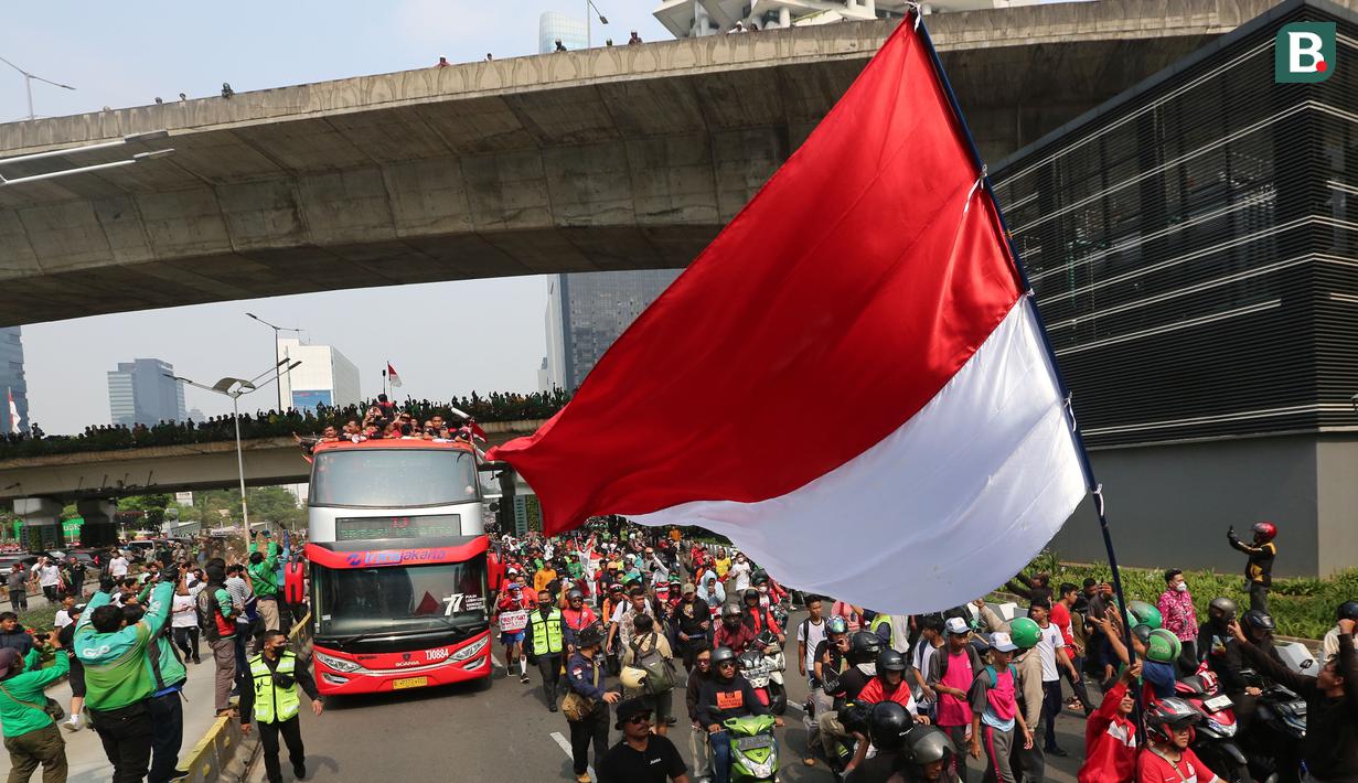 Bus yang ditumpangi Timnas Indonesia U-22 melewati pusat Flyover Karet saat pawai kontingen Indonesia untuk SEA Games 2023 yang bertajuk Kira87uara yang berlangsung di Jakarta, Jumat (19/05/2023). (Bola.com/Bagaskara Lazuardi)