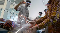 Siswa Sekolah Menengah Kejuruan memproduksi alat pelindung wajah (face shield) di Banda Aceh, Aceh, Jumat (12/6/2020). Selain memproduksi alat pelindung wajah, mereka juga membuat hand sanitizer yang akan disumbangkan untuk tenaga medis penanganan COVID-19. (CHAIDEER MAHYUDDIN/AFP)