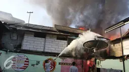 Warga menggunakan tabung pemadam untuk memadamkan api di kawasan Tanah Abang, Jakarta, Senin (5/9). Belum diketahui penyebab serta kerugian akibat kebakaran yang menghanguskan kawasan padat penduduk tersebut. (Liputan6.com/Immanuel Antonius)