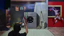 Seorang pria memfoto rekannya saat mengunjungi museum 3D di Jakarta, Minggu (7/11/2021). Museum 3D tersebut dibuka kembali setelah pelonggaran pembatasan Covid-19. (AFP/Adek Berry)