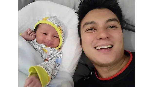 Bayi tampan ini terlihat tersenyum saat berfoto dengan ayahnya, terlihat begitu bahagia.