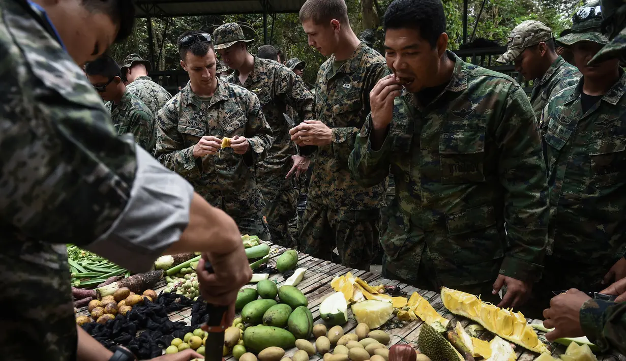 Marinir Thailand dan AS memakan buah dan sayuran yang berada di hutan saat latihan gabungan Cobra Gold antara militer AS dan Thailand di Chonburi, Thailand (19/2). (AFP Photo/Lilian Suwanrumpha)