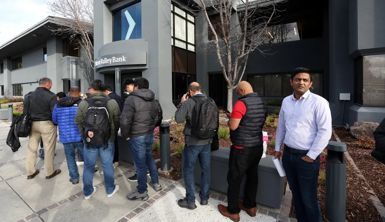Antrean nasabah untuk mencoba mengambil kembali dana mereka di luar kantor Silicon Valley Bank di Santa Clara, California, Senin (13/3/2023). Awal runtuhnya SVB mulai terlihat pada 8 maret 2023,  ketika SVB mengumumkan  telah menjual sejumlah sekuritas yang mengalami kerugian. (Justin Sullivan/Getty Images/AFP )